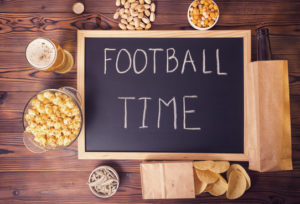 football fans concept of beer bottle in brown paper bag, chips,